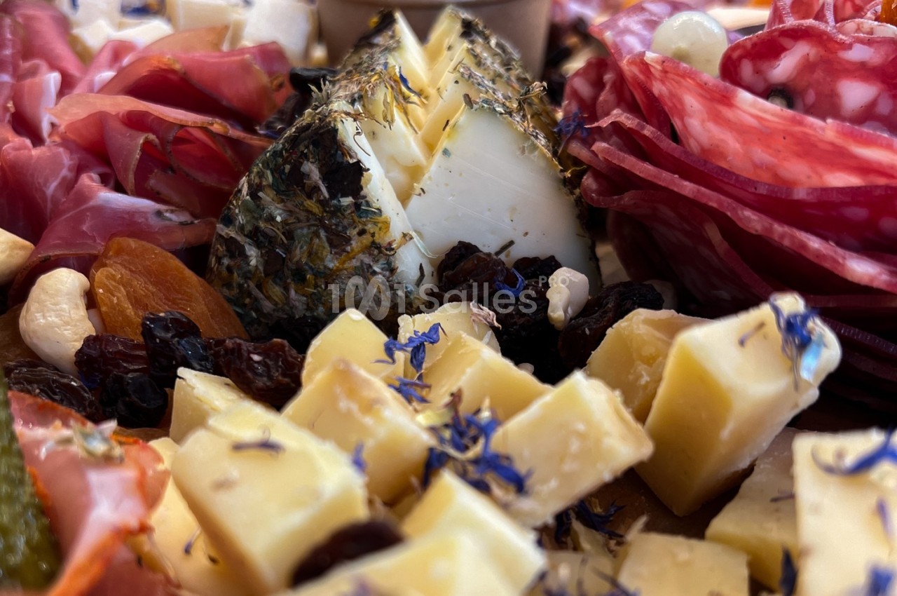 Plateau de charcuterie et fromages variés, agrémenté de fruits secs, herbes et fleurs comestibles.