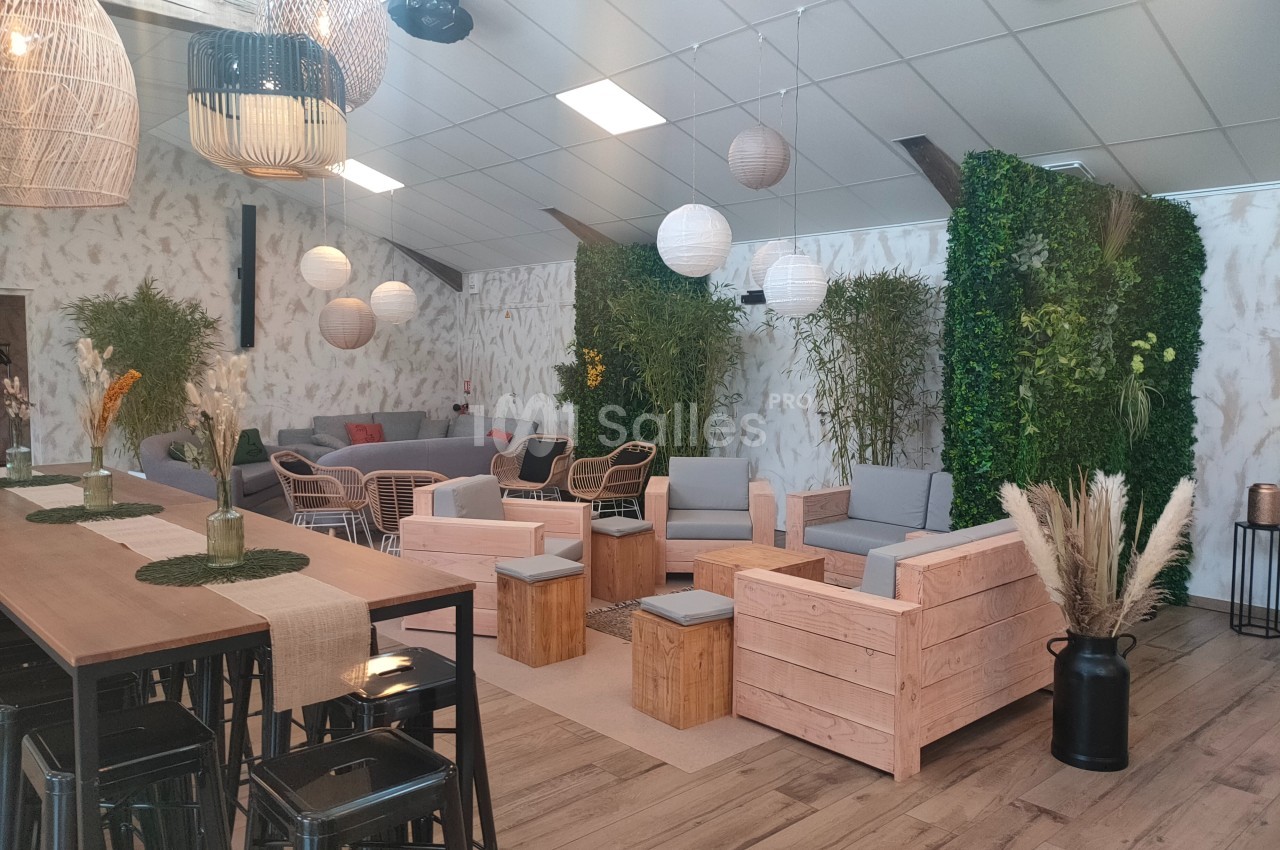 Espace intérieur lumineux avec mobilier en bois, plantes vertes, lampes suspendues et décoration naturelle.