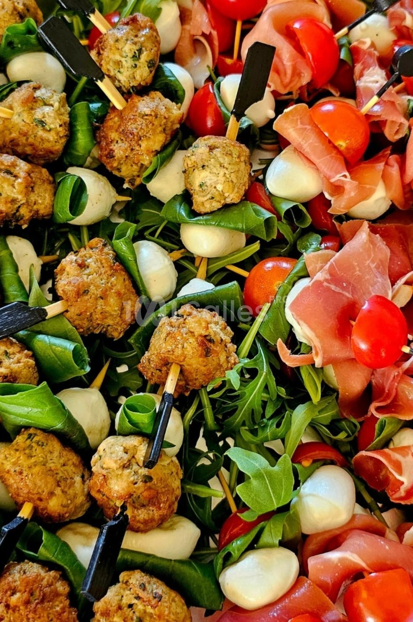 Plateau de brochettes variées avec boulettes, mozzarella, tomates cerises, roquette et jambon cru.
