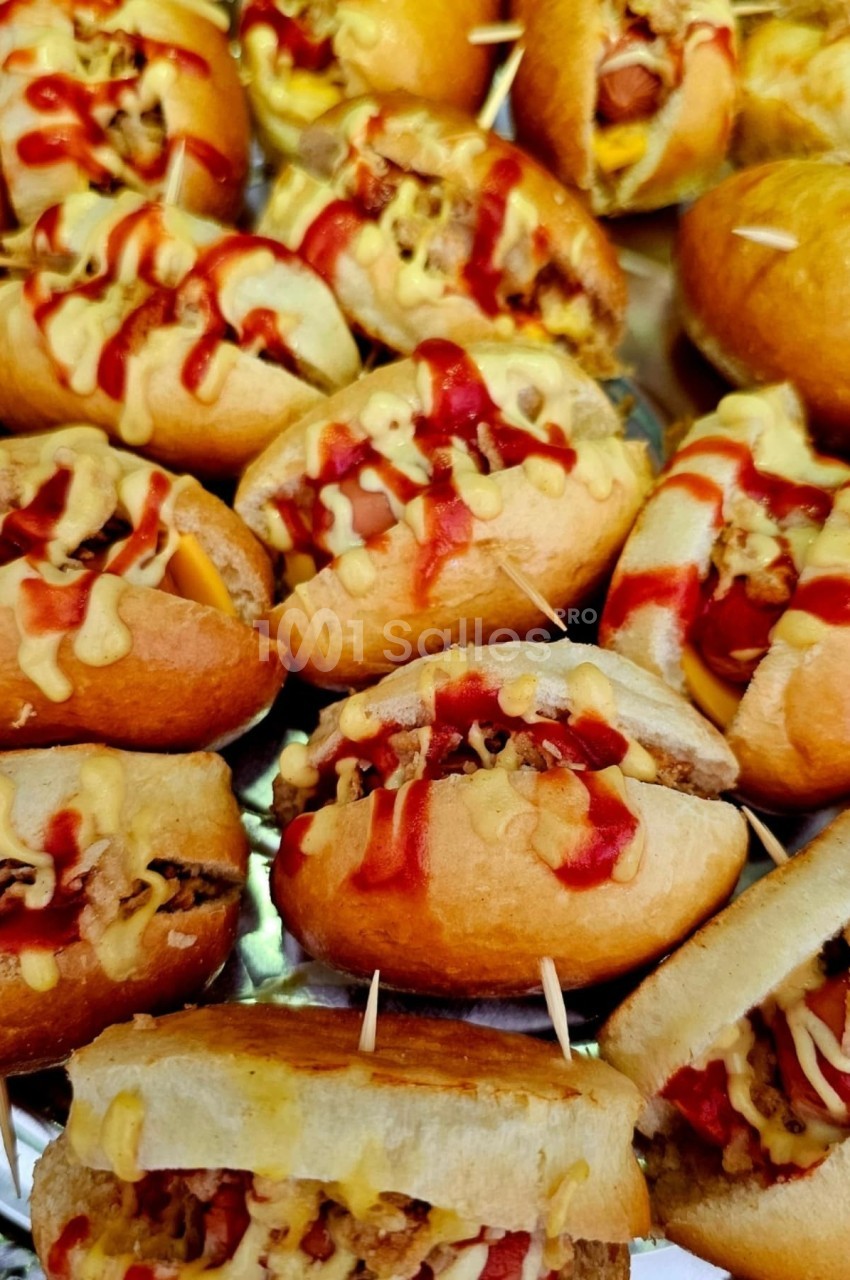 Plateau de petits sandwichs garnis de viande, fromage fondu et sauce ketchup-moutarde, maintenus par des piques.