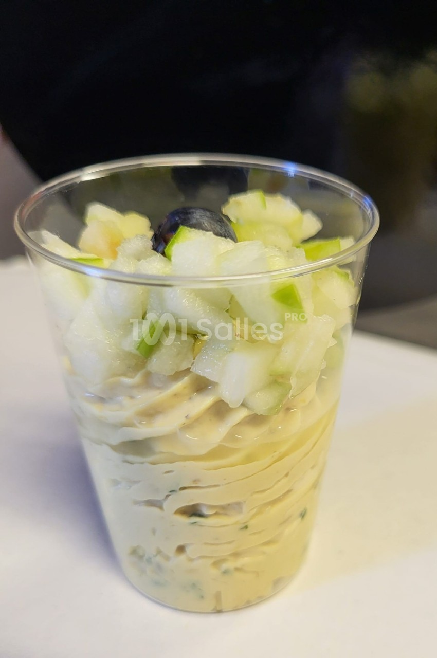 Verrine garnie de mousse crémeuse, dés de pomme verte et une myrtille en décoration.