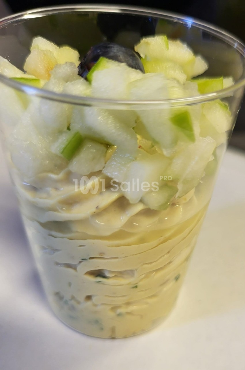 Verrine garnie de mousse crémeuse, dés de pomme verte et une myrtille en décoration.