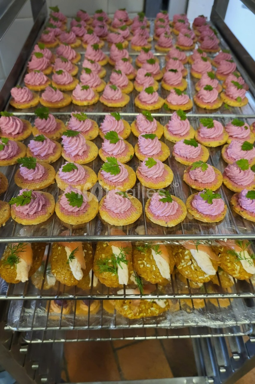 Plateaux de bouchées apéritives garnies de mousse rose et de persil, et de roulés au saumon et aneth.