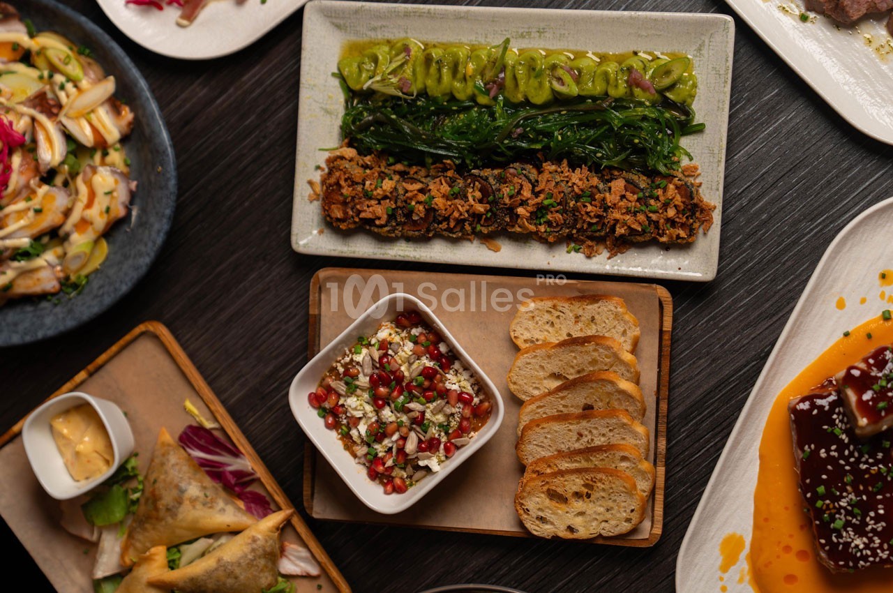 Assortiment de plats variés sur une table, incluant légumes, tartines, salade et entrées colorées.