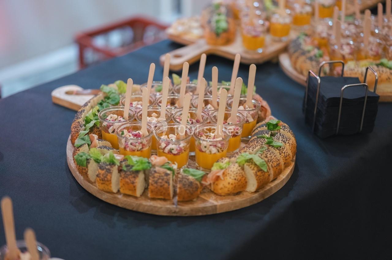 Plateau de verrines colorées et pains garnis disposés sur une table noire pour un buffet.