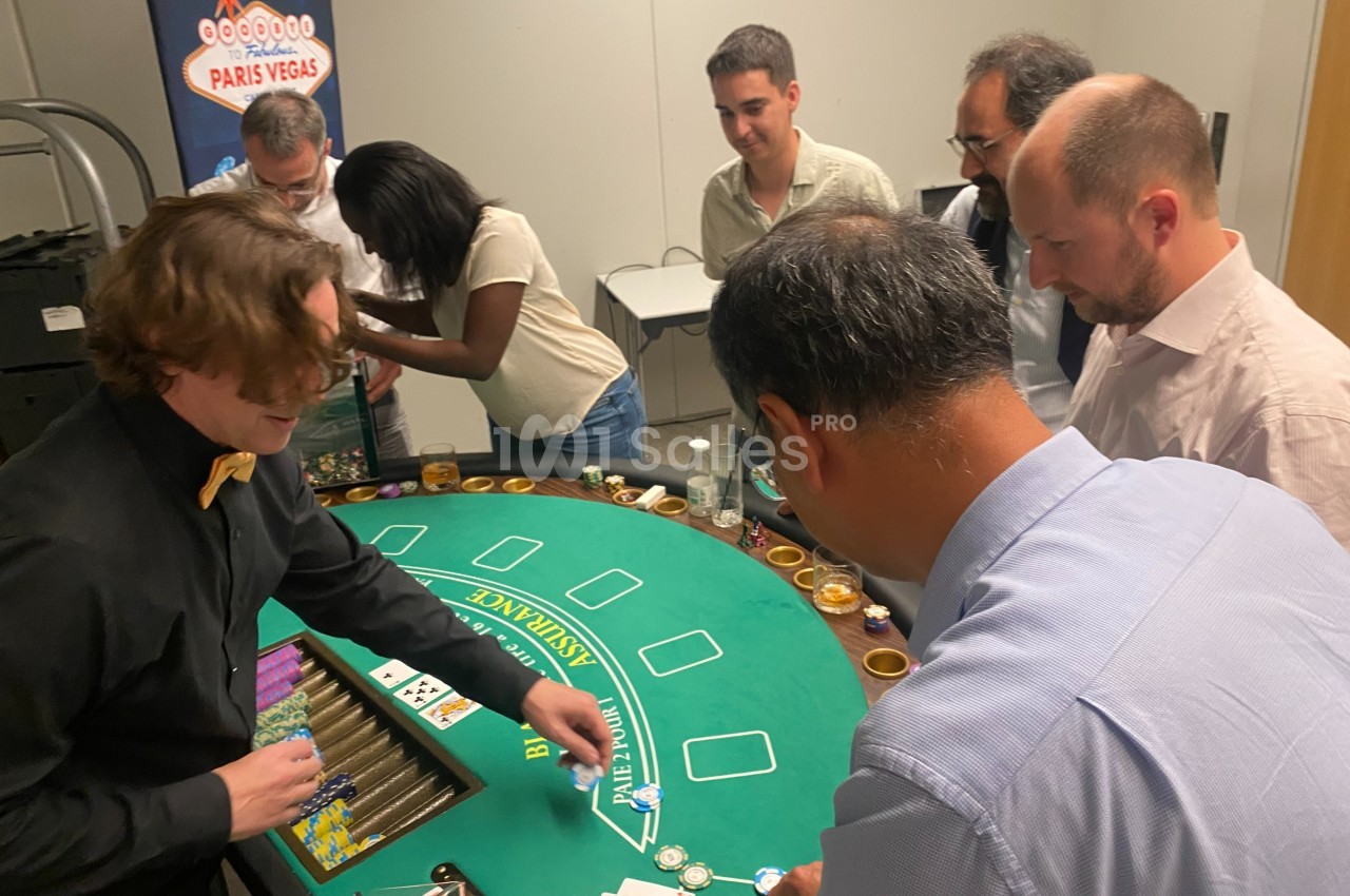Des personnes jouent autour d'une table de casino avec un croupier distribuant des cartes.