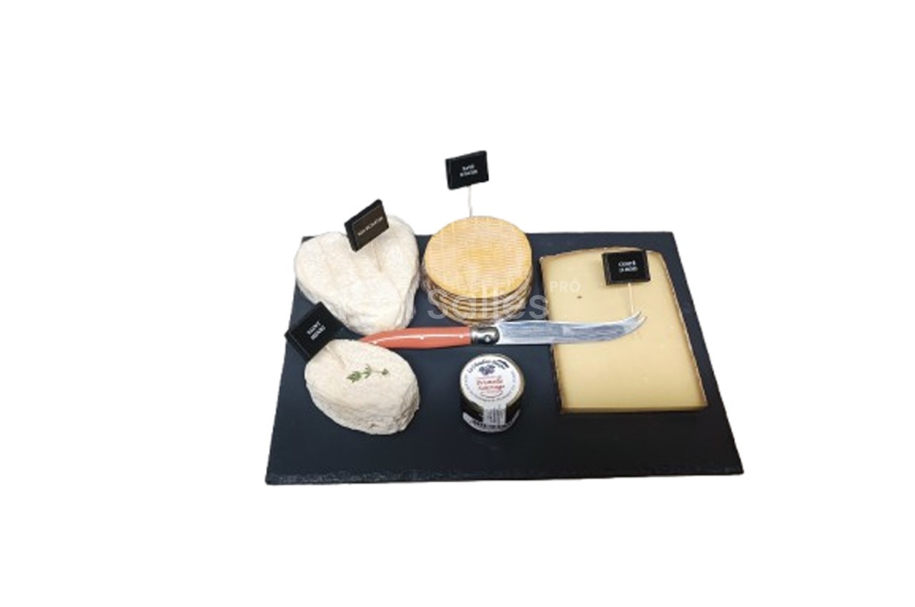 Plateau de fromages variés avec couteau, étiquettes descriptives et confiture sur une ardoise noire.
