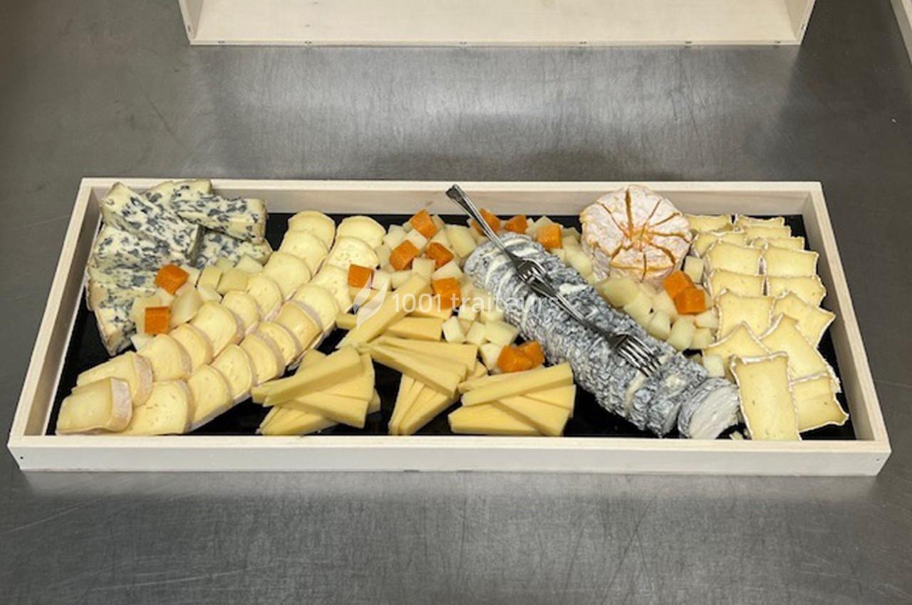 Plateau de fromages variés disposés en rangées, incluant fromages à pâte molle, dure, persillée et chèvre cendré.