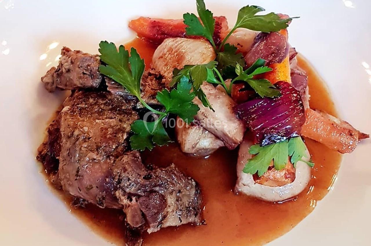 Assiette de viande braisée accompagnée de légumes rôtis et garnie de feuilles de persil.