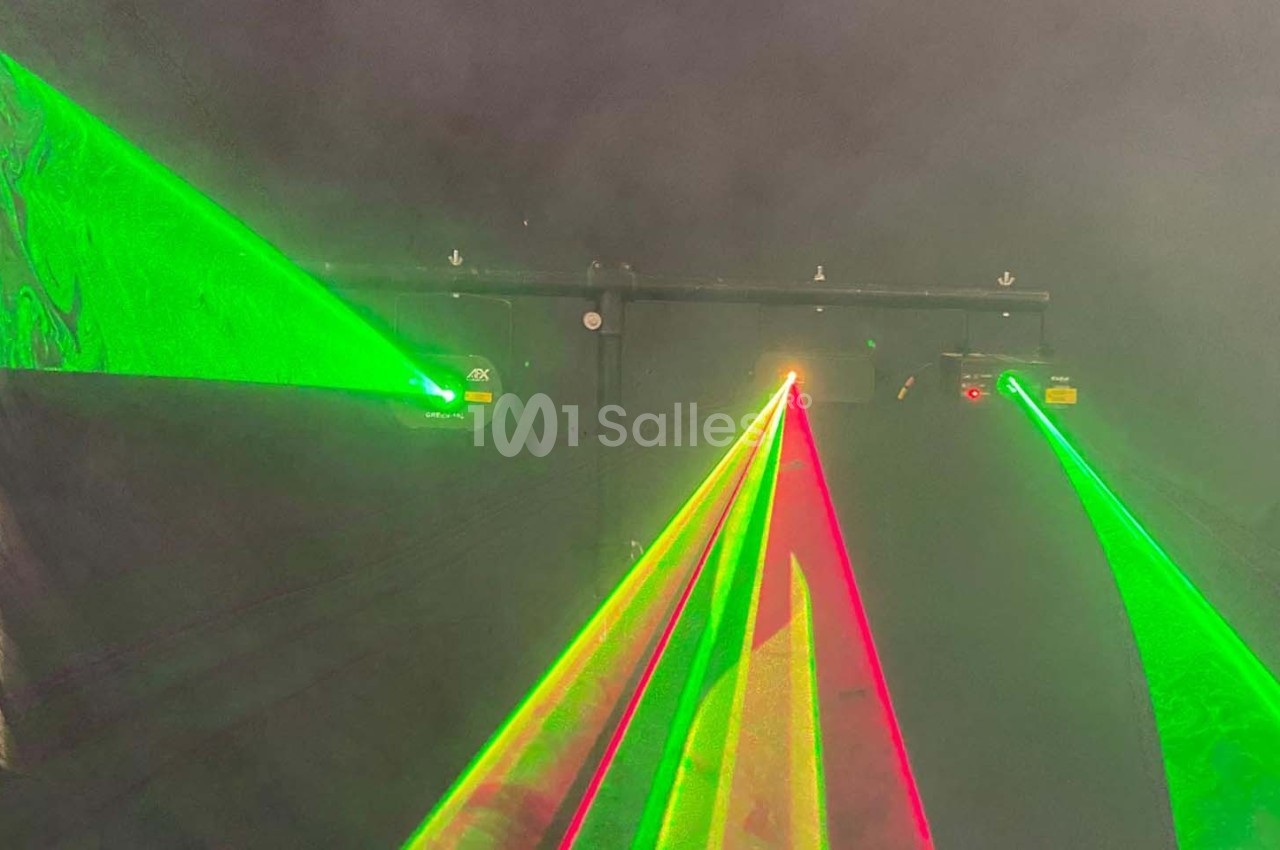 Faisceaux laser verts et rouges projetés dans une atmosphère enfumée, créant un effet lumineux vibrant.
