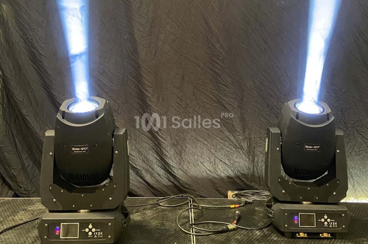 Deux projecteurs de scène émettant des faisceaux lumineux blancs sur un fond noir.
