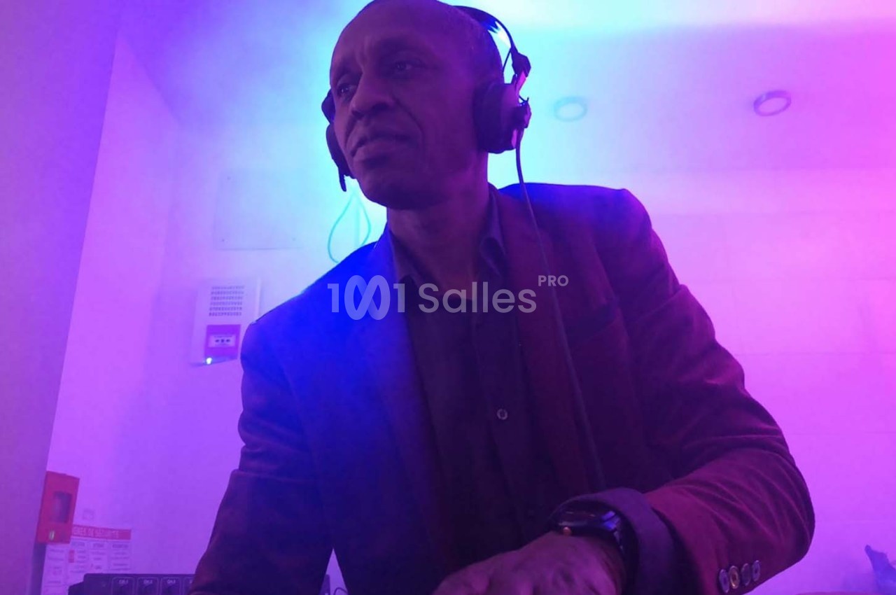 Homme portant un casque audio, concentré, dans une ambiance lumineuse violette et bleue.