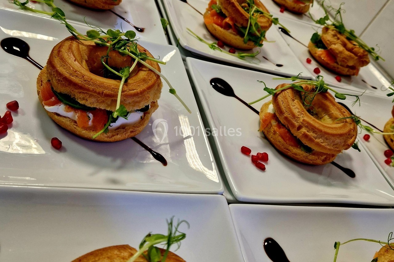 Choux garnis de saumon, fromage frais et herbes, présentés sur des assiettes avec décoration de balsamique et grenade.
