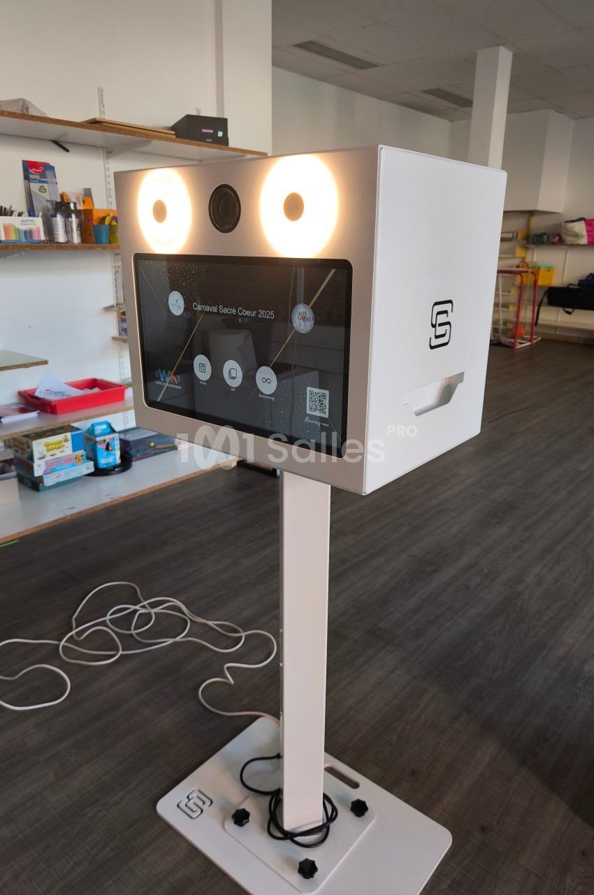 Borne photo interactive sur pied avec écran tactile et éclairage intégré, installée dans un espace intérieur.