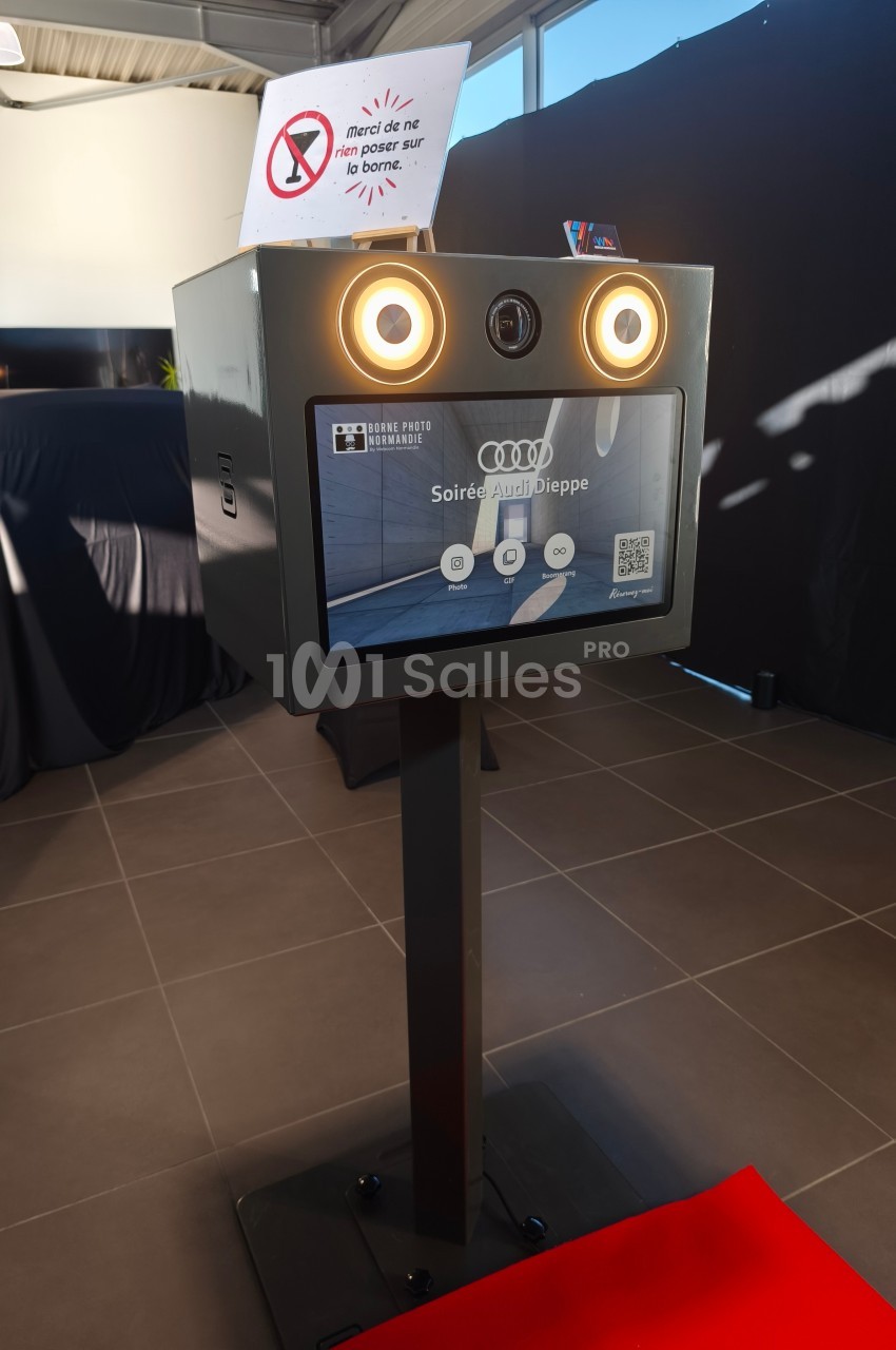 Borne photo interactive avec écran tactile, éclairage intégré et panneau d'instructions dans un espace intérieur.