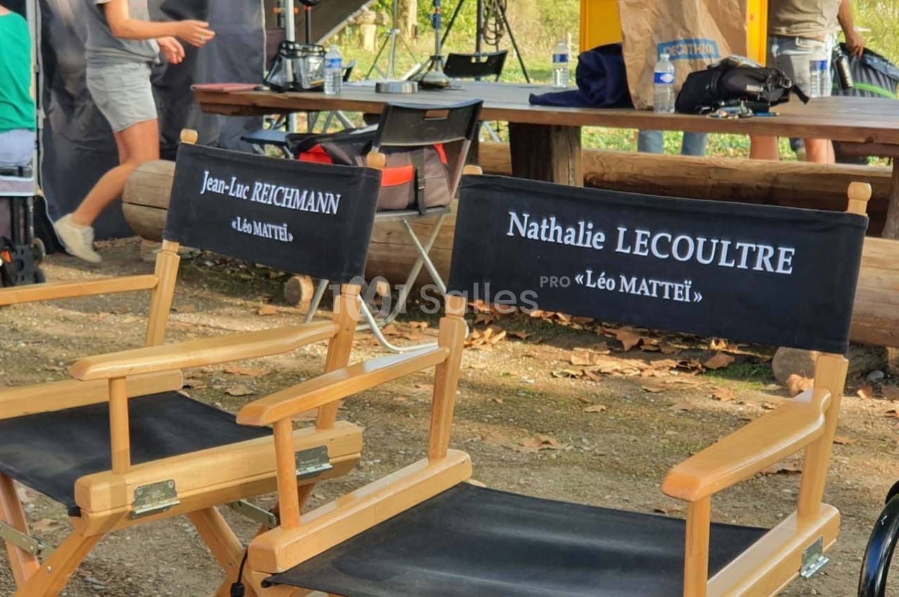 Deux chaises de réalisateur en bois avec les noms ’Jean-Luc Reichmann’ et ’Nathalie Lecoultre’ inscrits sur le dossier.