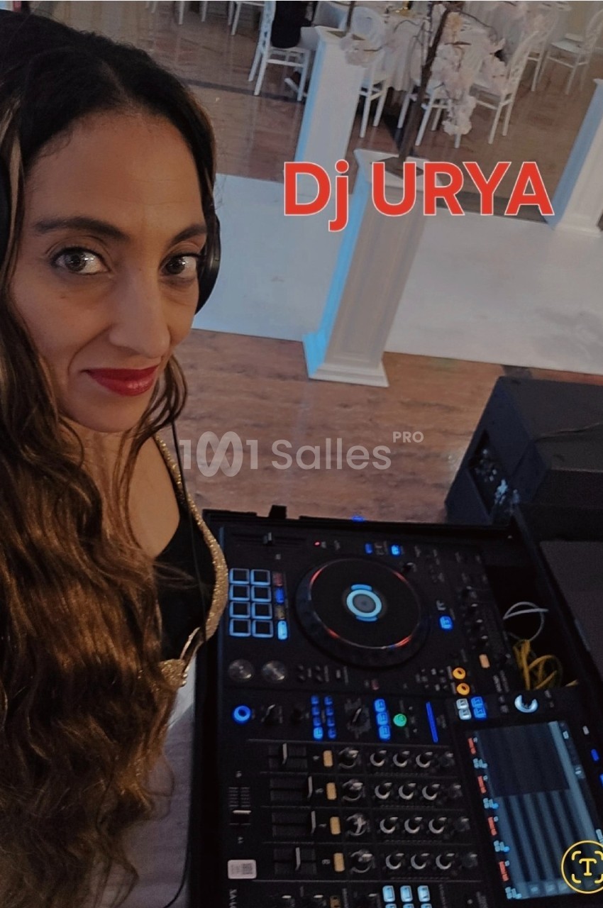 Femme avec casque audio devant une table de mixage dans un espace intérieur décoré pour un événement.