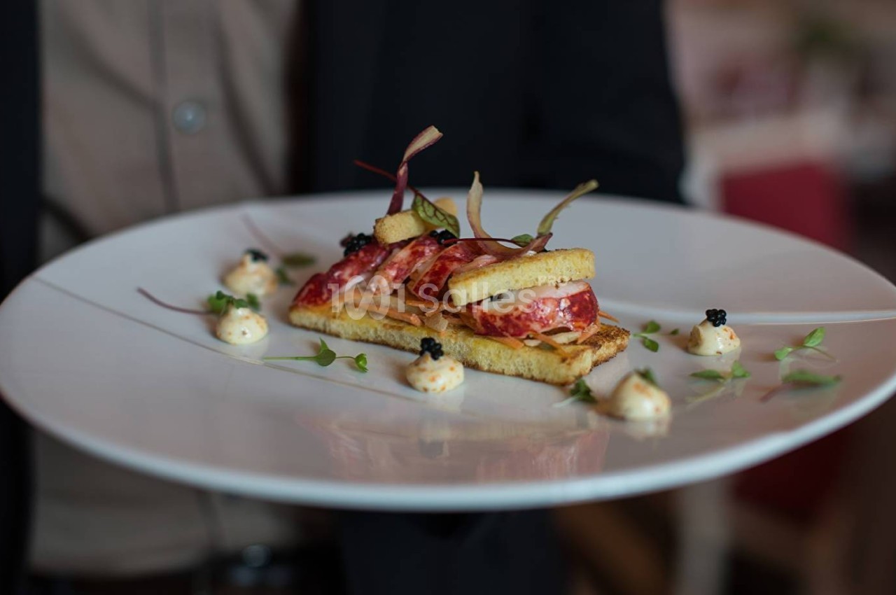 Assiette gastronomique avec une présentation soignée de toasts, charcuterie, mousse et garnitures décoratives.