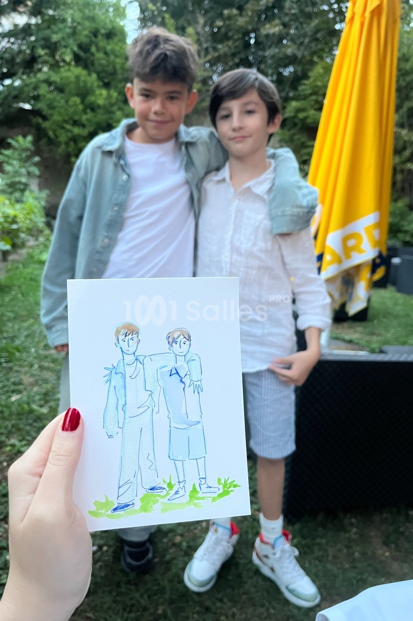 Deux enfants posant ensemble dans un jardin, avec un dessin les représentant tenu au premier plan.