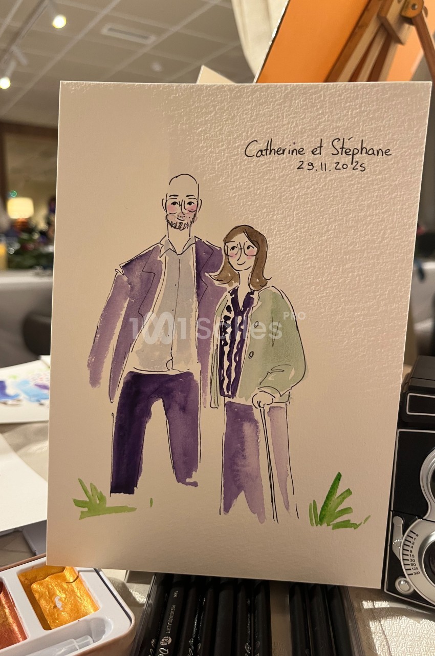 Illustration d'un couple souriant, peinte à l'aquarelle, posée sur une table avec des fournitures d'art.