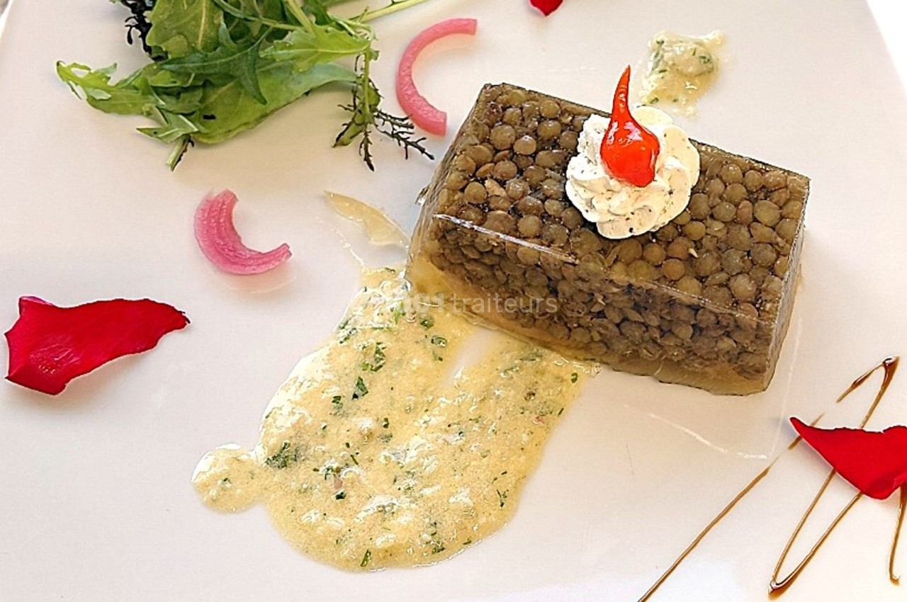 Plat gastronomique composé d'un cube de lentilles en gelée, crème aux herbes, salade verte et décorations colorées.