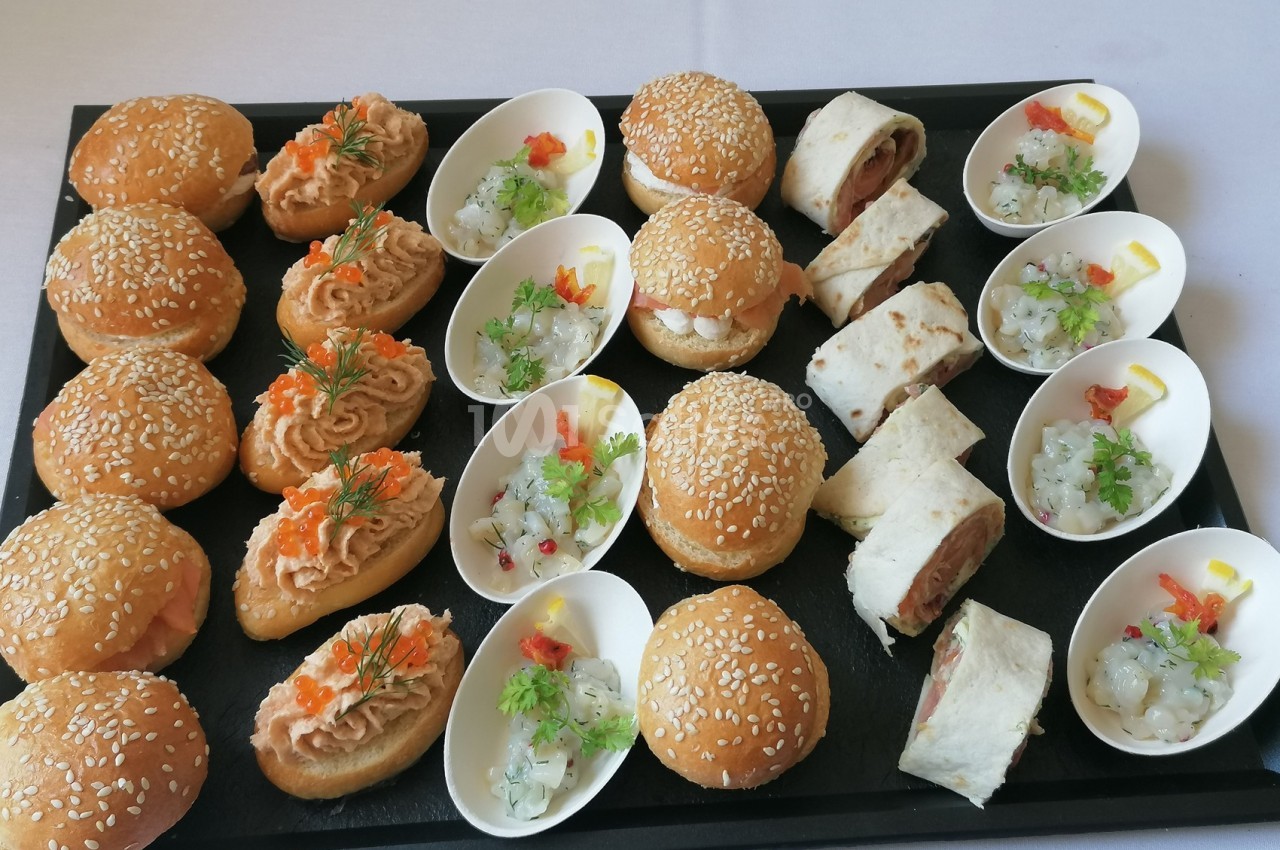 Plateau de bouchées apéritives variées comprenant mini-burgers, wraps, verrines et toasts garnis.