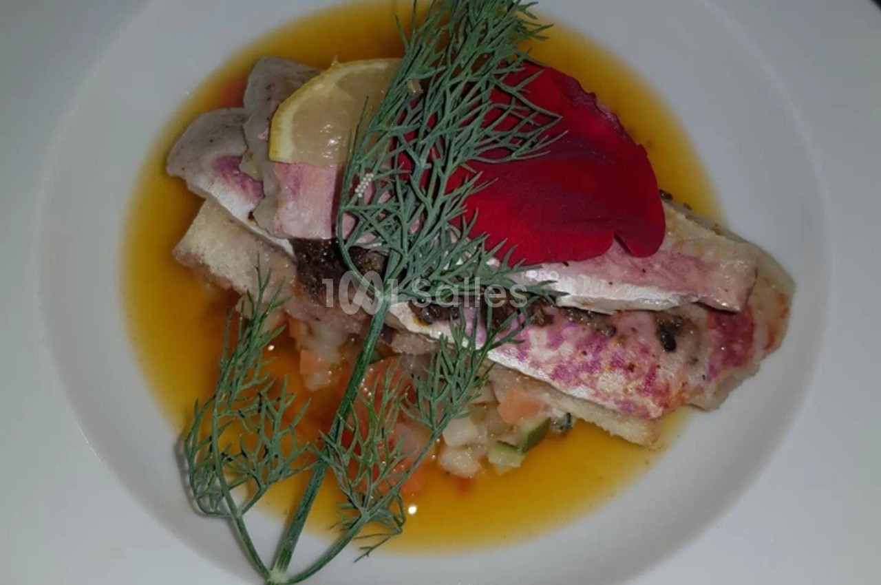 Filets de poisson dressés sur un lit de légumes, nappés de sauce, garnis d'aneth, d'une tranche de citron et d'un pétale…
