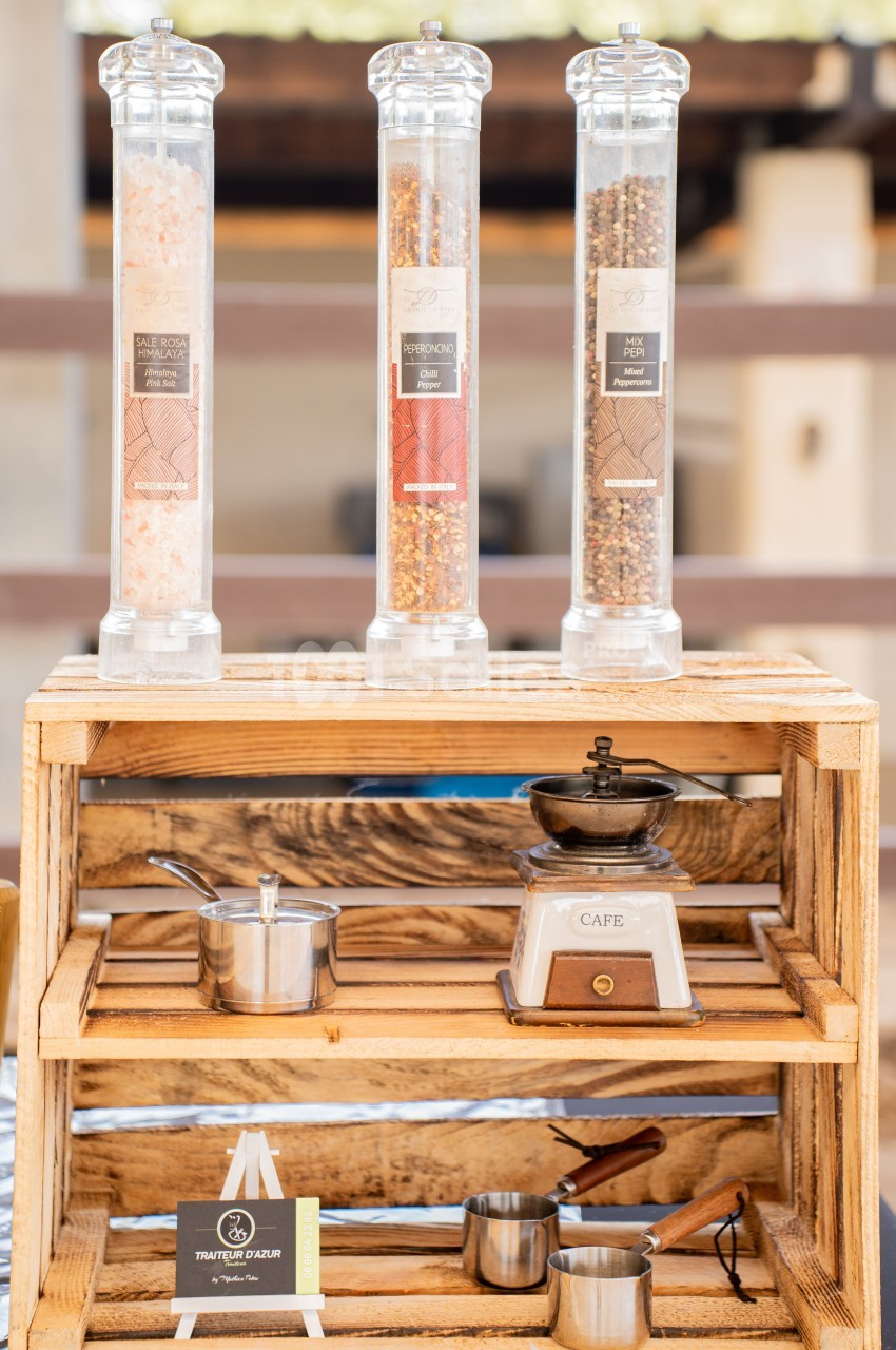 Trois moulins à épices sur une étagère en bois avec une balance vintage et des ustensiles de cuisine en métal.