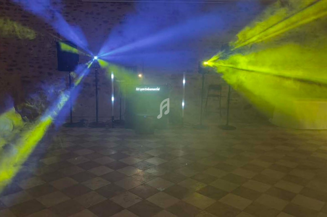 Jeu de lumières colorées bleues et jaunes projetées dans une salle avec sol carrelé et murs en pierre.