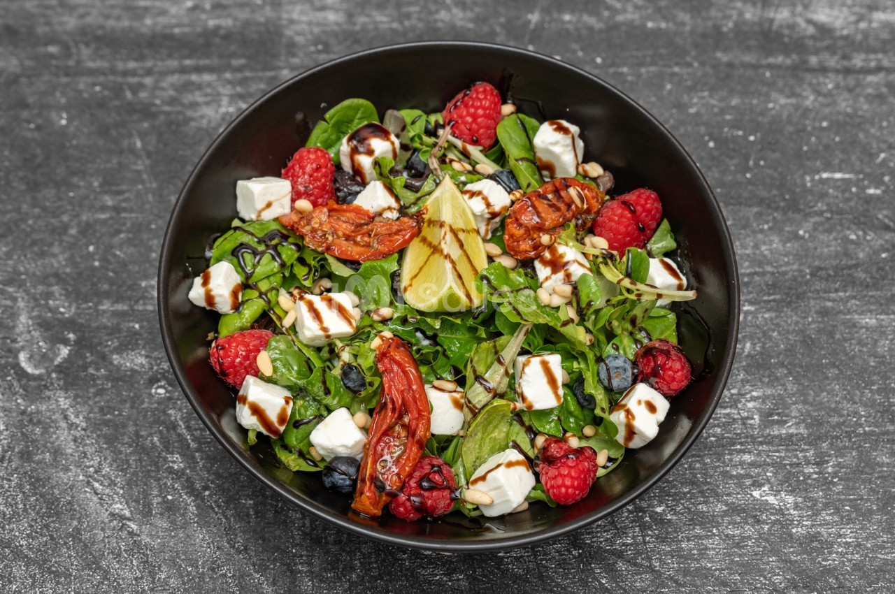 Salade composée de jeunes pousses, tomates confites, framboises, myrtilles, feta, graines et vinaigre balsamique.