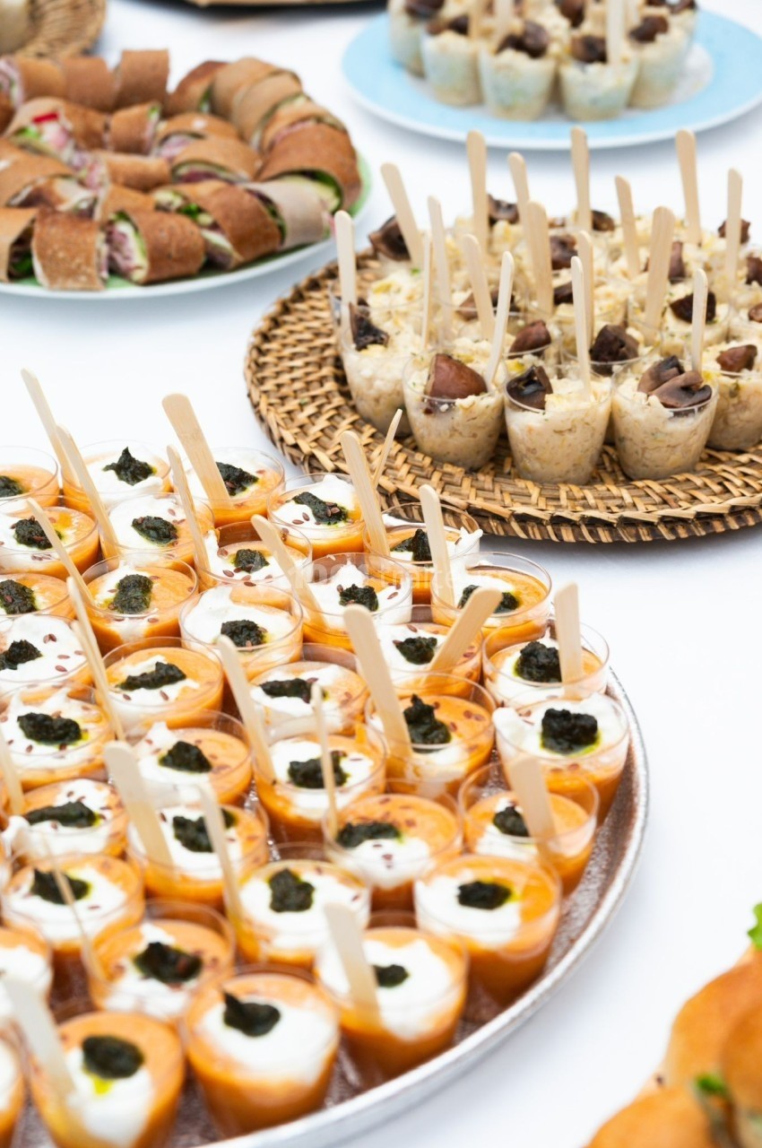 Plateau de verrines et amuse-bouches variés disposés sur une table lors d'un buffet.