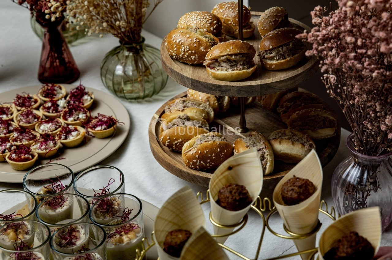 Buffet avec mini-burgers, verrines, tartelettes et fleurs séchées en décoration.