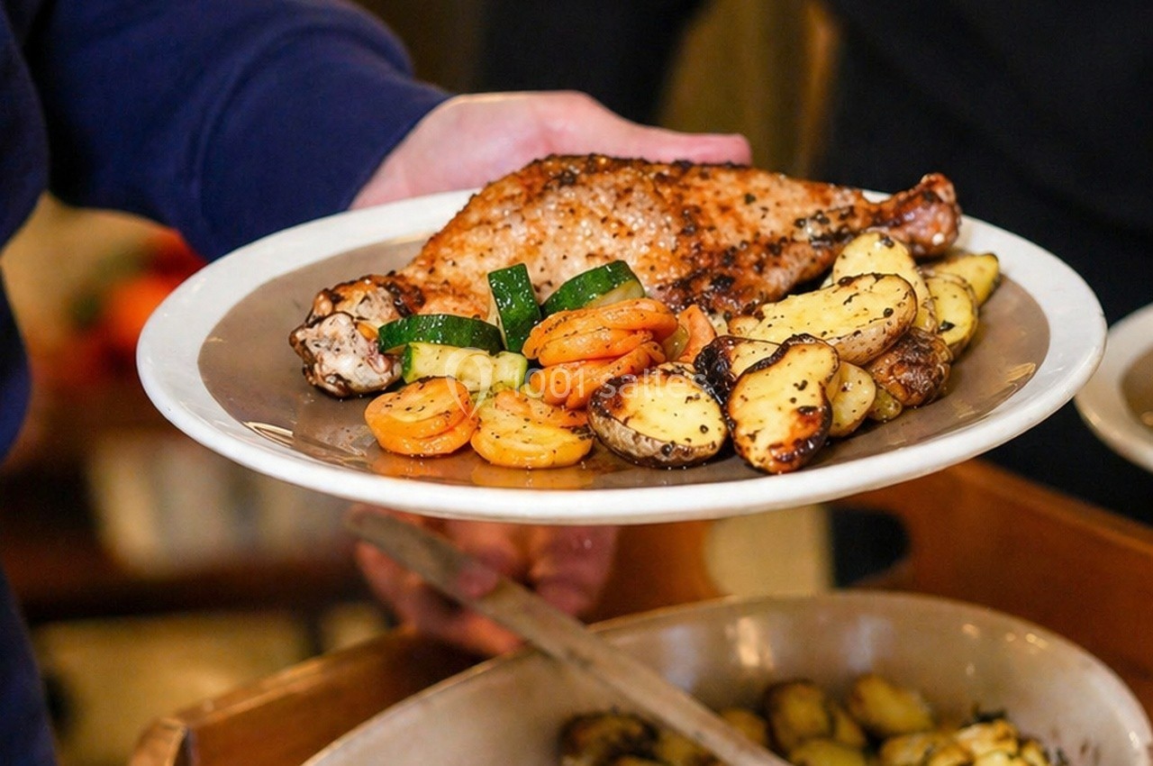 Assiette contenant une cuisse de poulet grillée, des rondelles de carottes, des courgettes et des pommes de terre rôties.