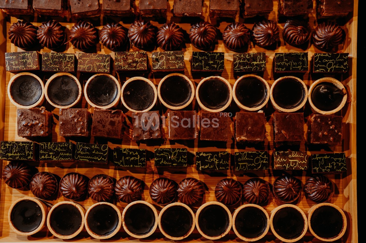 Assortiment de desserts au chocolat disposés en rangées sur une table en bois.