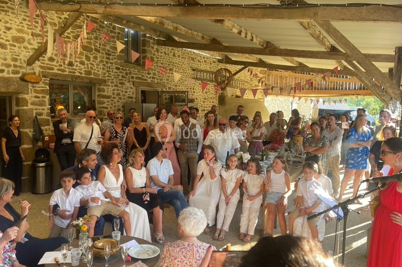 Un groupe de personnes rassemblées dans une cour couverte, décorée de guirlandes, lors d'un événement festif.