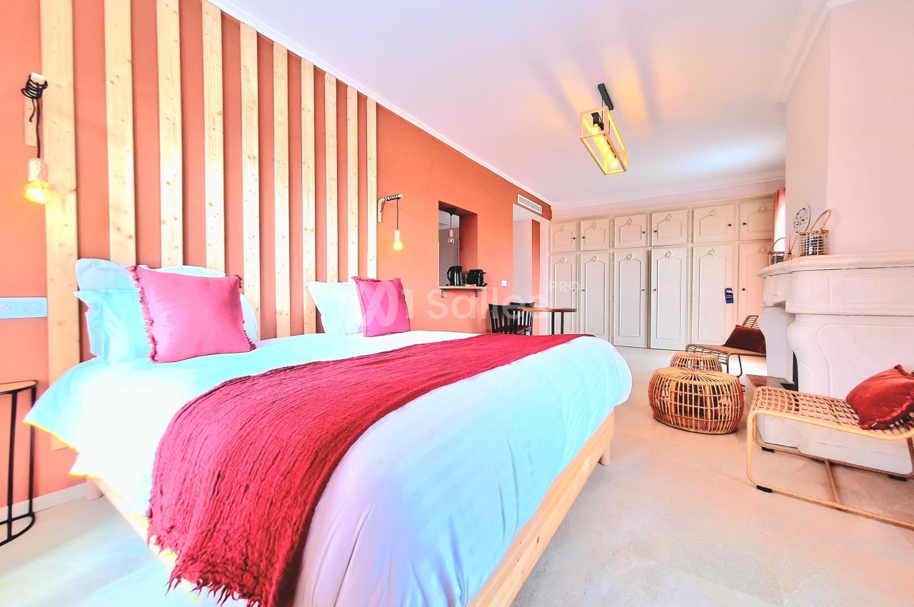 Chambre lumineuse avec lit double, mur en bois, décoration chaleureuse et mobilier moderne.
