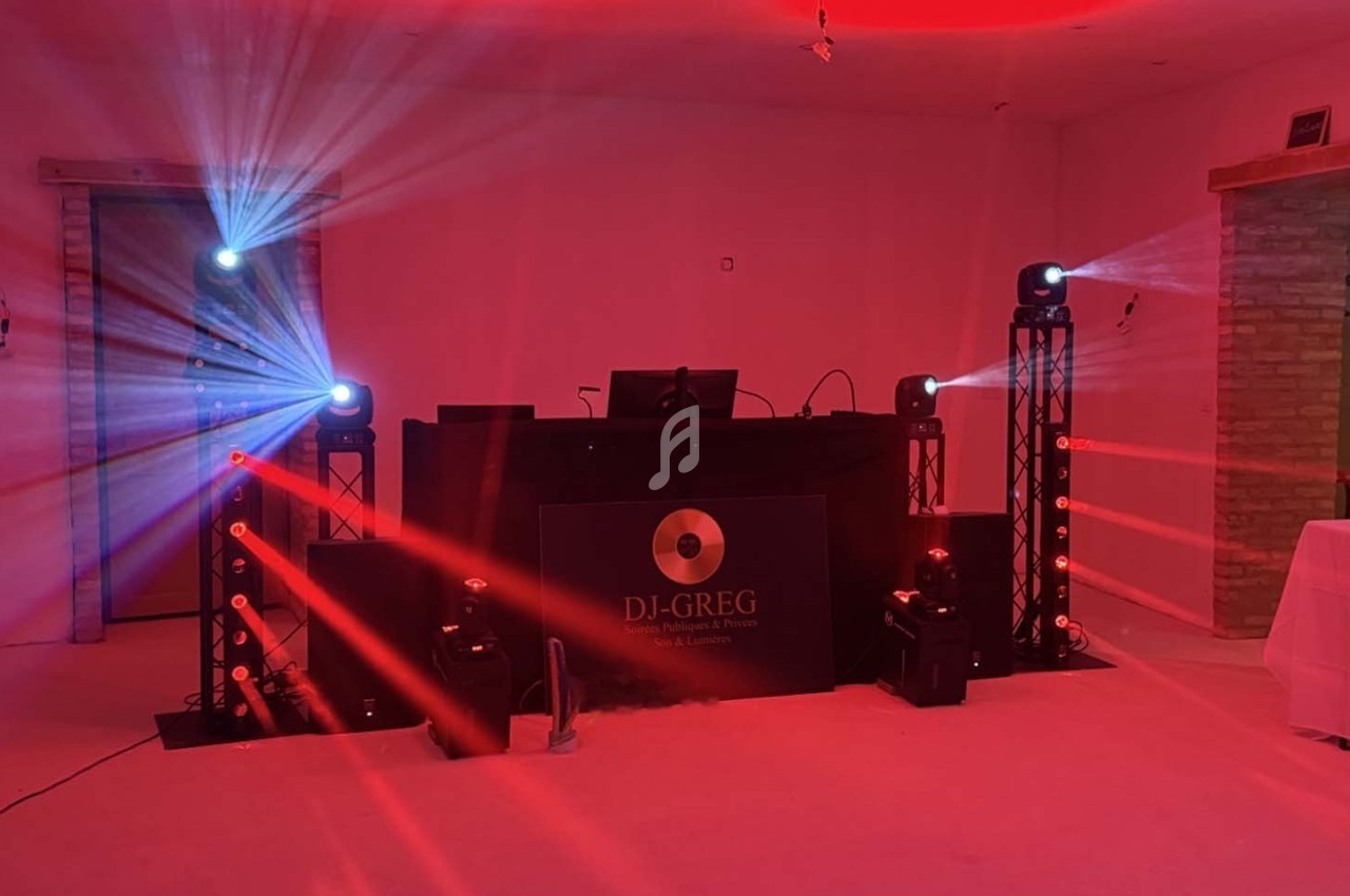 Installation de matériel de DJ avec jeux de lumières rouges et bleues dans une salle intérieure.