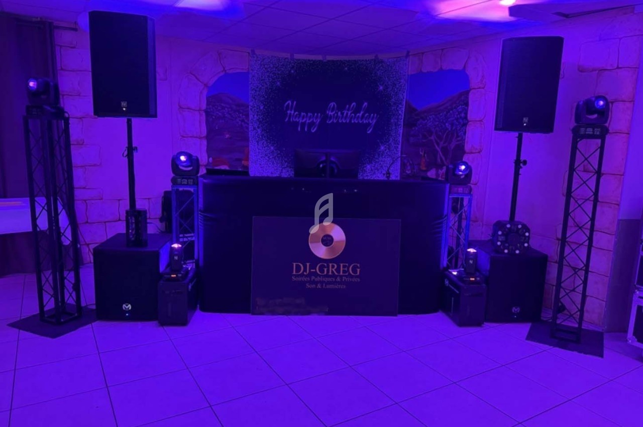 Installation de matériel de sonorisation et éclairage avec une table de mixage dans une salle décorée pour un anniversaire.