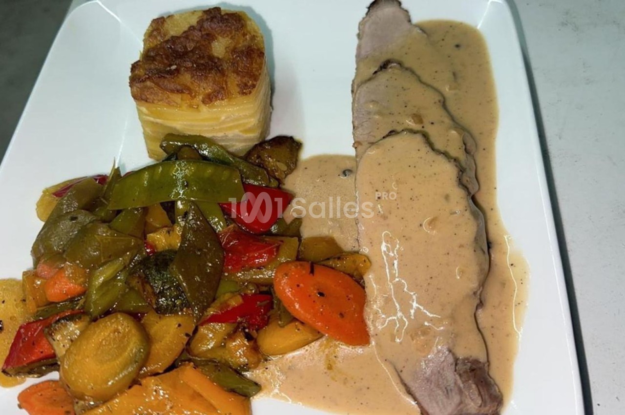 Assiette composée de tranches de viande en sauce, gratin dauphinois et légumes sautés colorés.