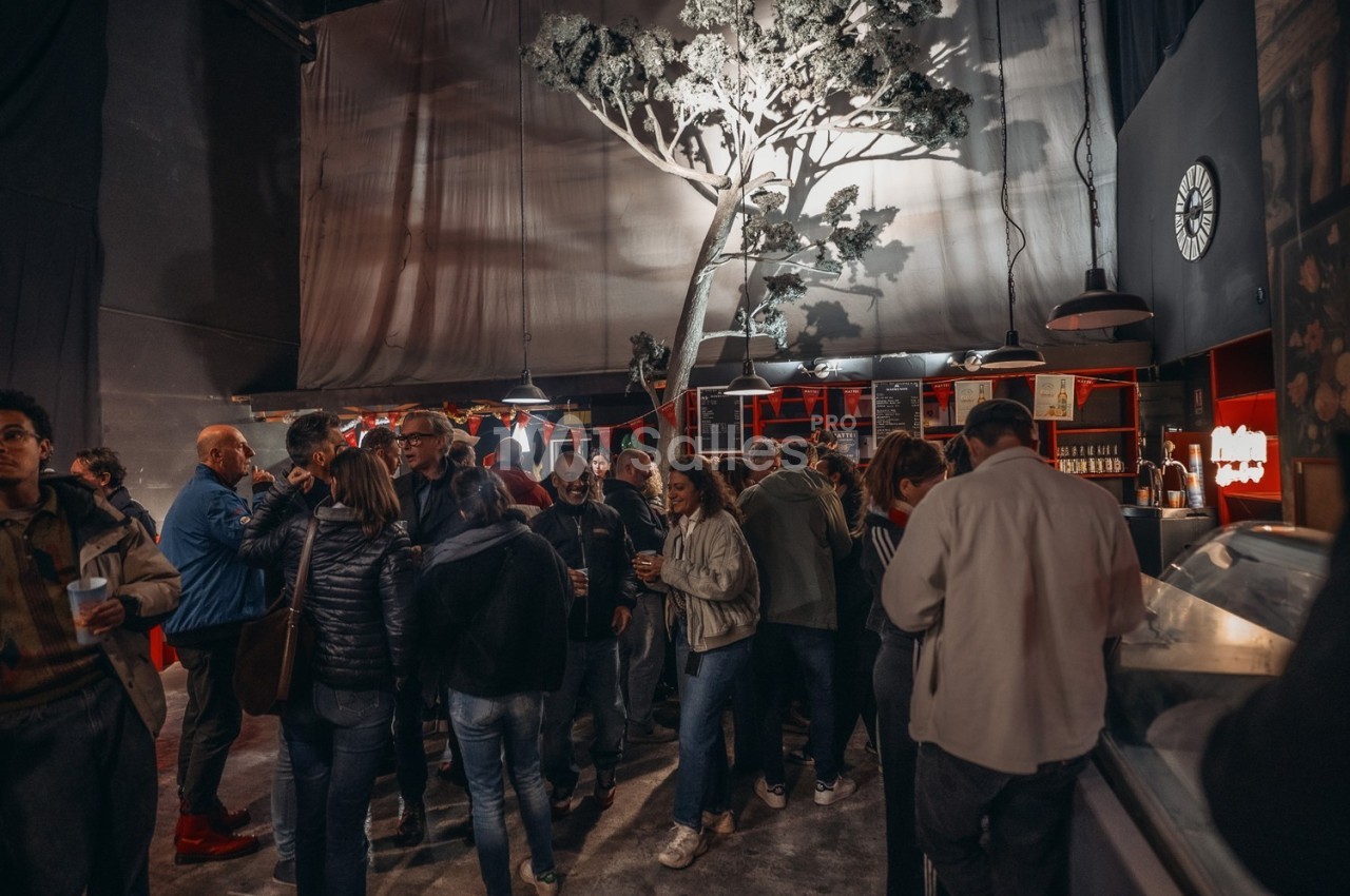 Groupe de personnes rassemblées dans un espace intérieur avec un décor d'arbre éclairé et un comptoir en arrière-plan.