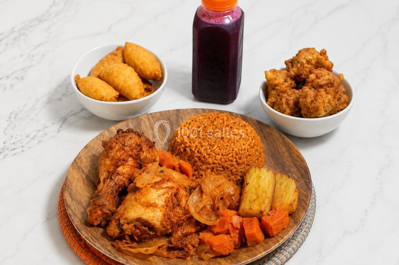 Assiette de riz épicé avec poulet, légumes, accompagnée de beignets, acras et une bouteille de jus violet.