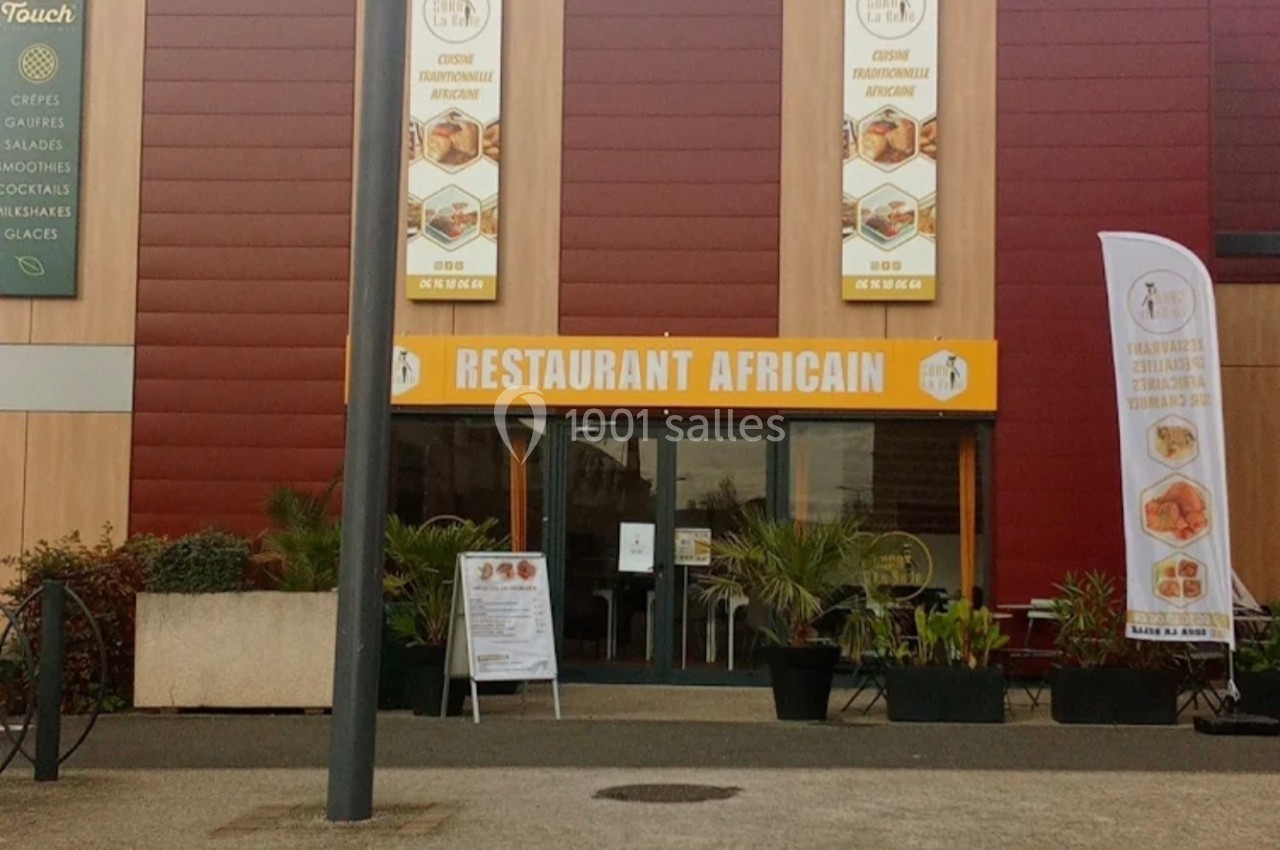 Façade d'un restaurant africain avec enseigne visible, affiches et plantes en extérieur.