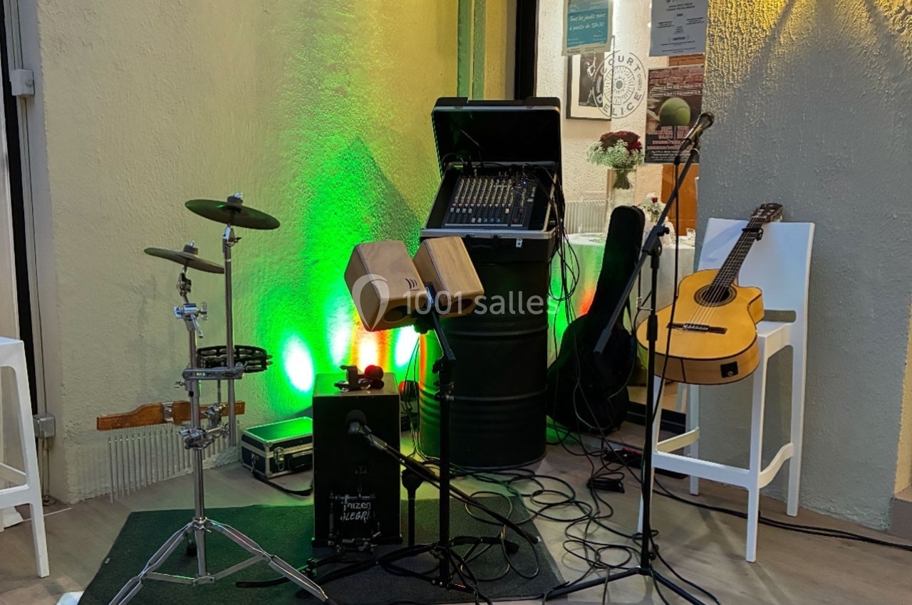 Instruments de musique et matériel de sonorisation installés en extérieur, éclairés par une lumière verte.