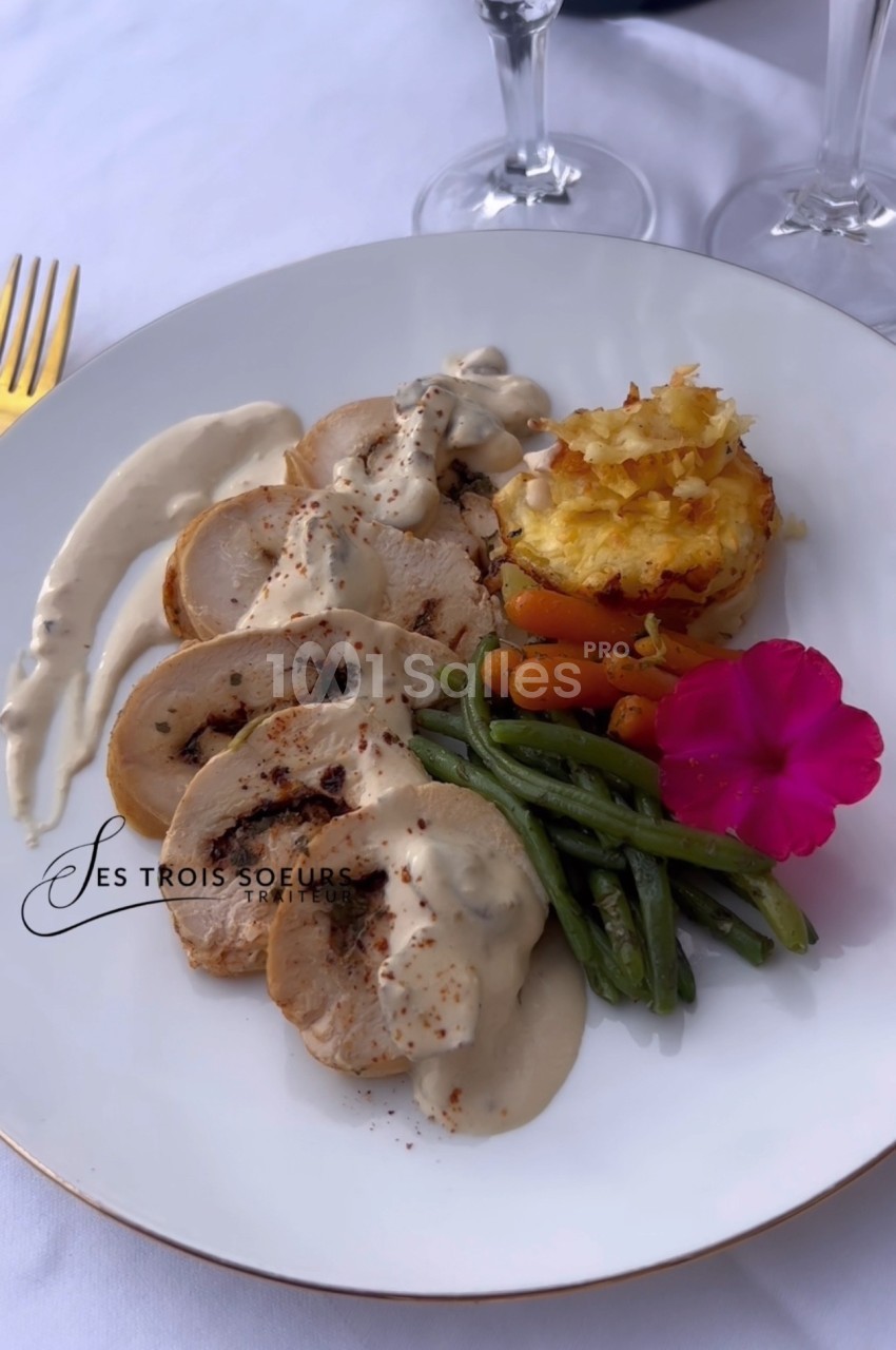 Assiette de poulet sauce crème, haricots verts, carottes, gratin de pommes de terre et fleur comestible en décoration.