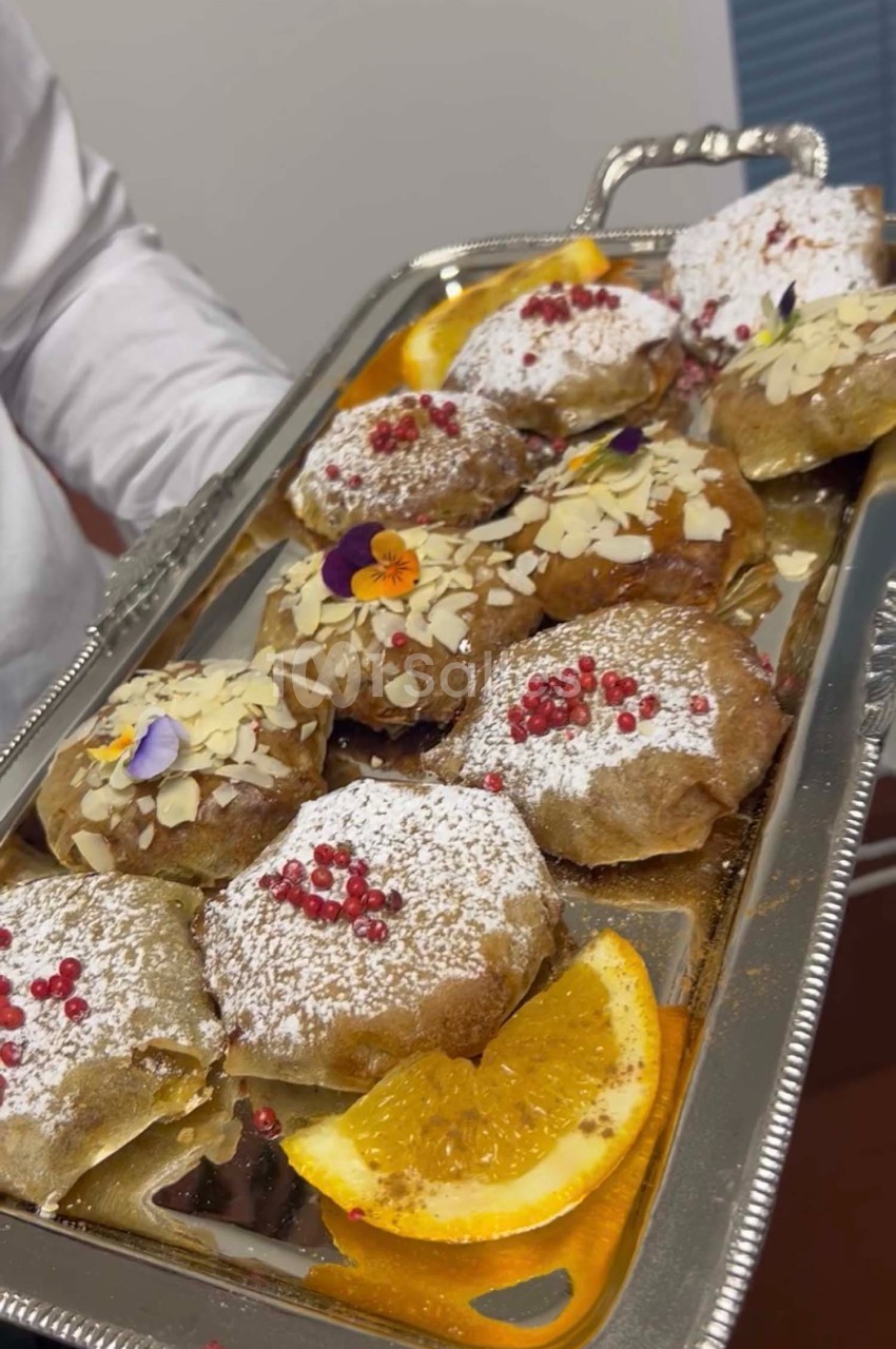 Plateau de pâtisseries décorées de sucre glace, amandes effilées, baies rouges et fleurs comestibles, avec des tranches d…
