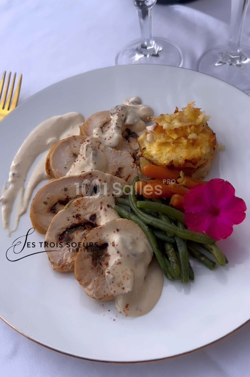 Assiette composée de tranches de volaille sauce crème, haricots verts, carottes, gratin et fleur comestible.