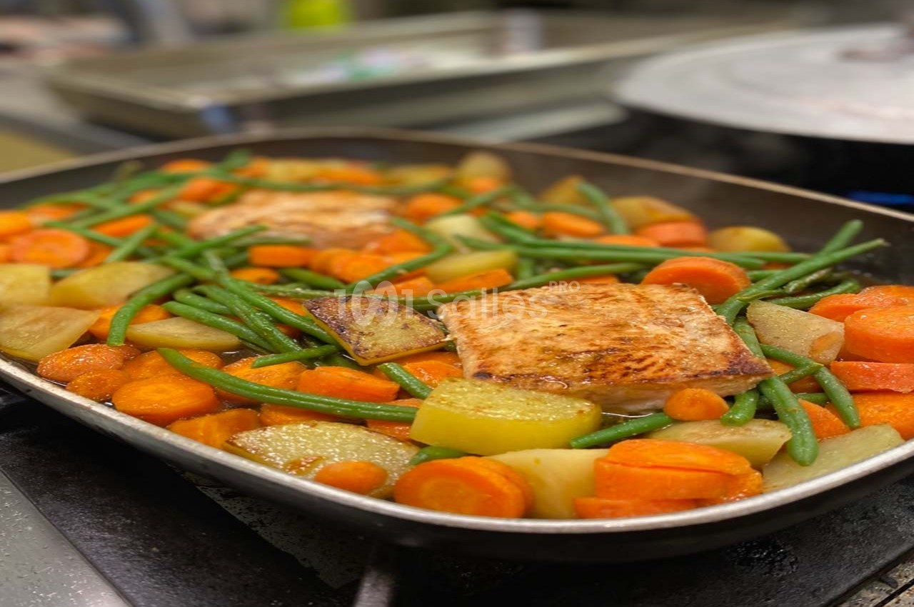 Filet de saumon rôti avec haricots verts, carottes et pommes de terre dans un plat de cuisson.