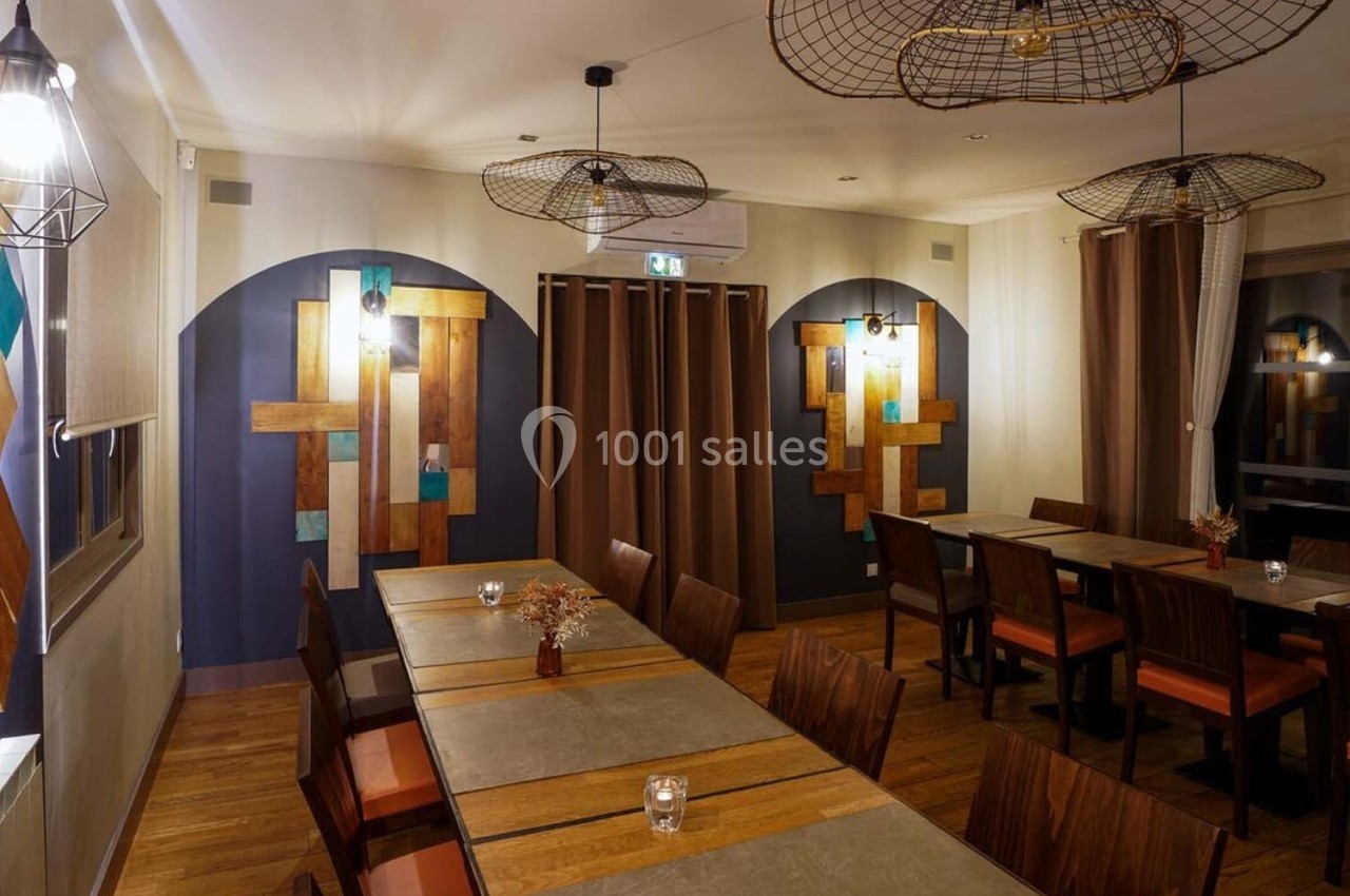 Salle de restaurant moderne avec tables en bois, chaises assorties et éclairage suspendu, décorée de panneaux muraux colorés.