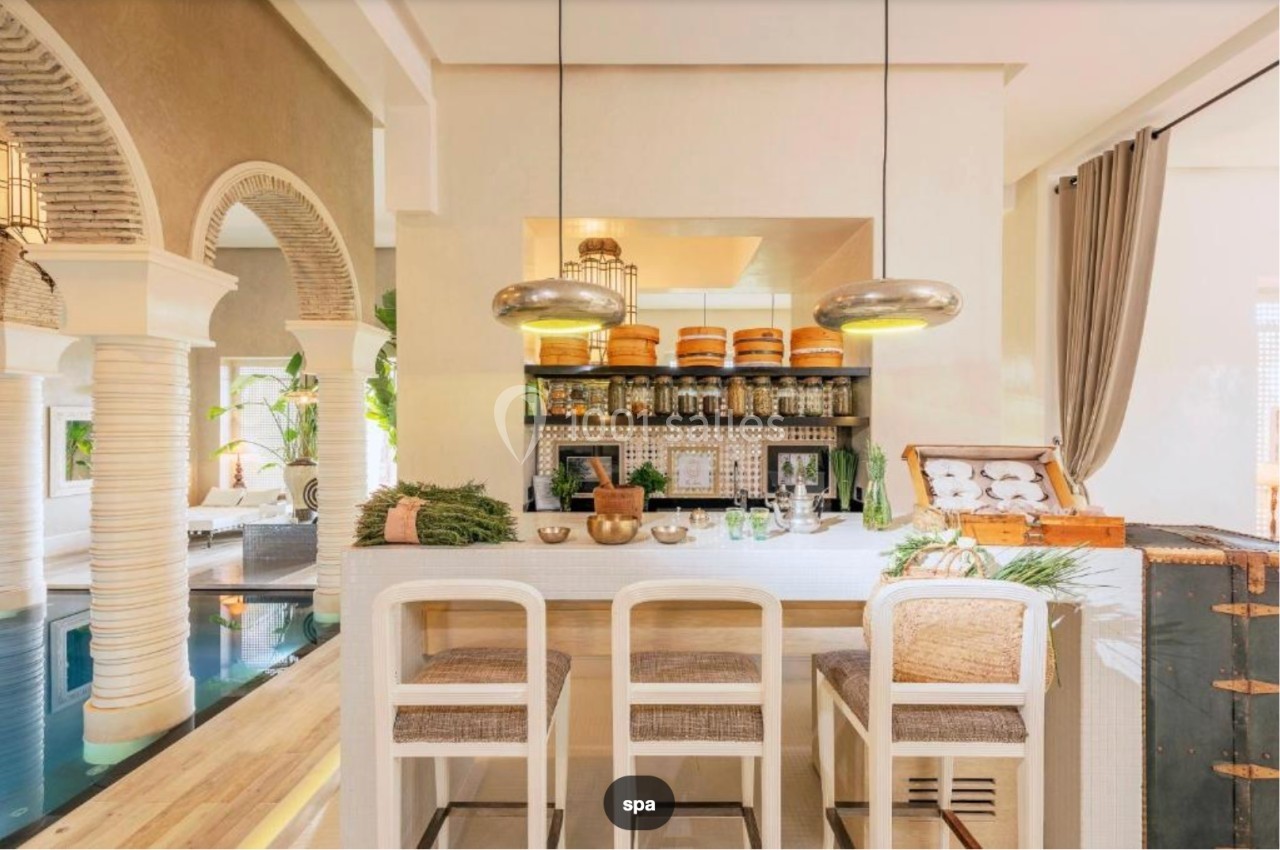 Espace lumineux avec un bar en bois clair, étagères garnies de pots, et décoration naturelle dans un cadre élégant.