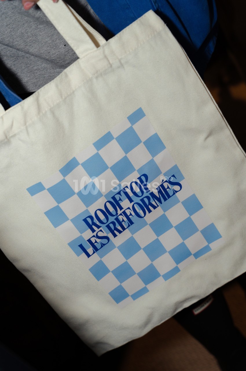 Tote bag blanc en coton imprimé avec damier bleu et texte "Rooftop Les Réformés".
